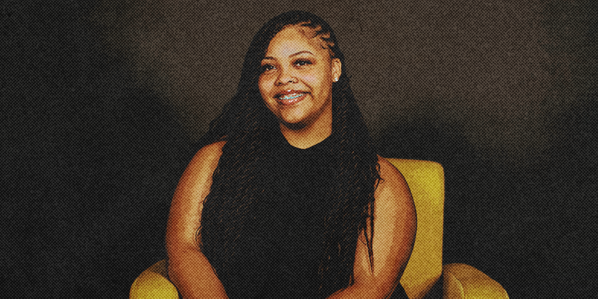 Profile picture of Shawnie Holbrook sitting on a yellow accent chair.
