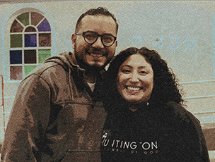 Hispanic married couple standing in front of a church
