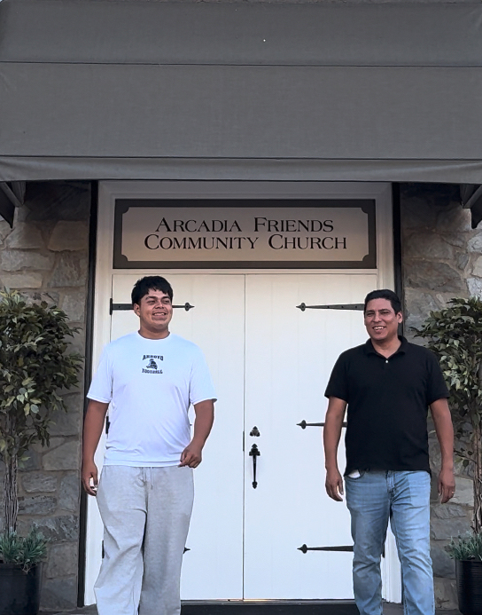 Hispanic pastor with student smiling